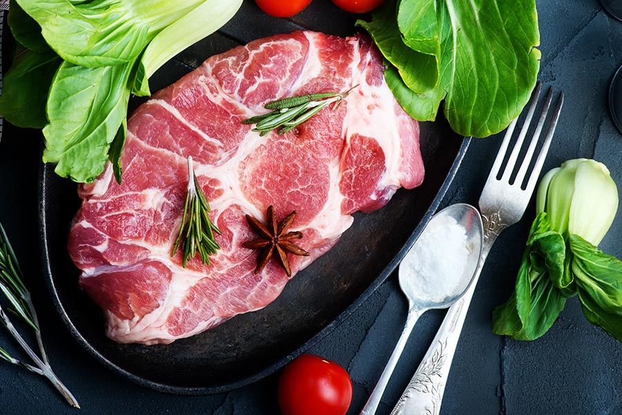 Frisches, rohes Fleisch auf einem Teller mit Gewürzen